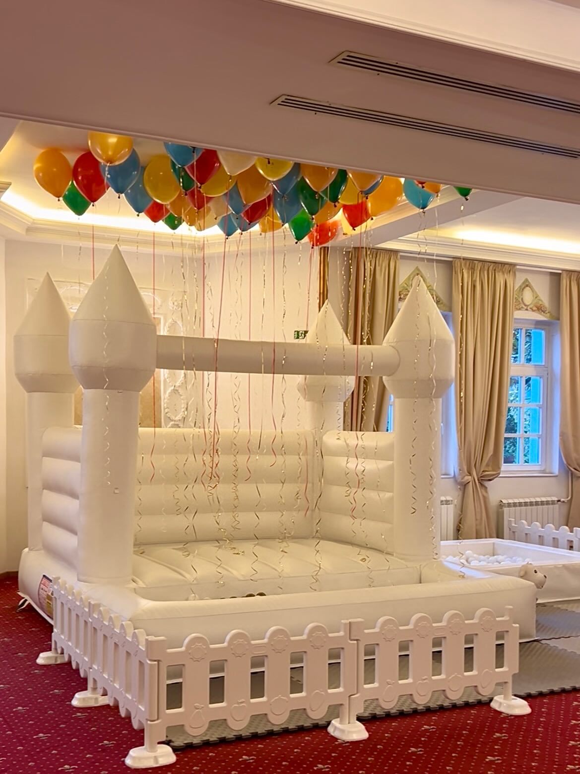 Beli dvorac u eleganatnoj sali sa balonima